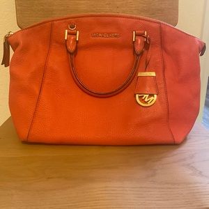 Medium to large coral color Micheal Kors handbag.